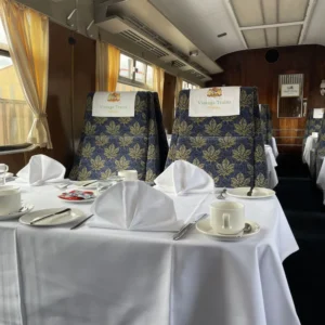 Two seats aboard the Pullman train with a fully set dining table in front of them